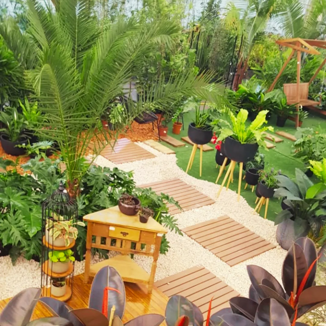 Jardim tropical com caminho de pisantes de madeira